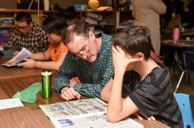 chris reading the comics with student