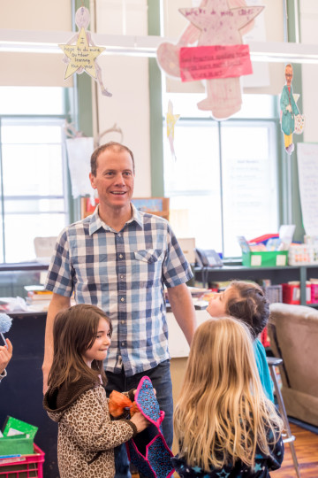 Tom smiling with students